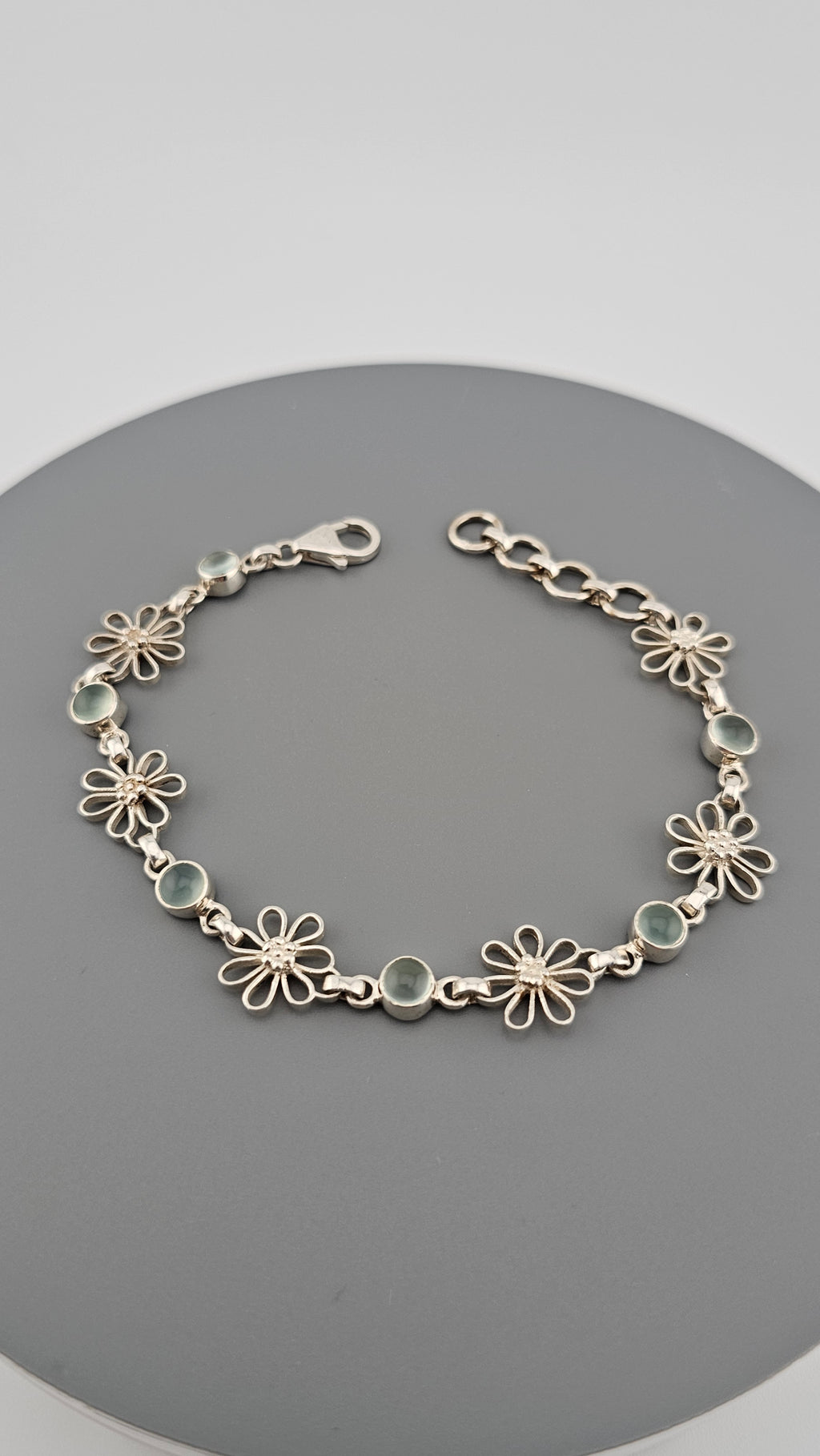925 sterling silver daisy link bracelet featuring light blue, round cabochon aquamarine
