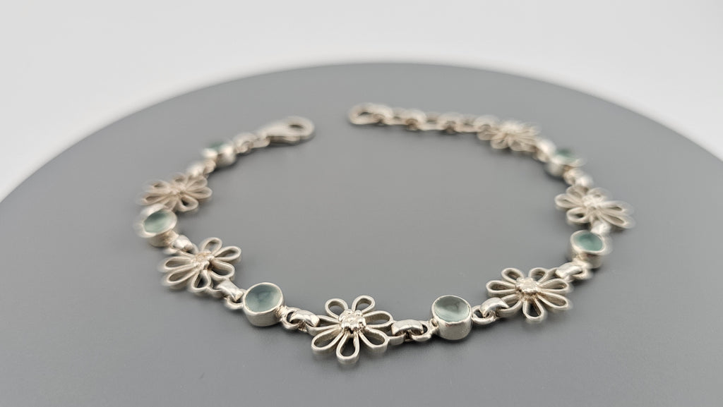 925 sterling silver daisy link bracelet featuring light blue, round cabochon aquamarine