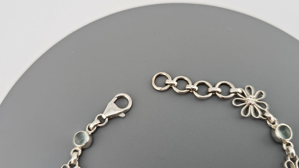 925 sterling silver daisy link bracelet featuring light blue, round cabochon aquamarine