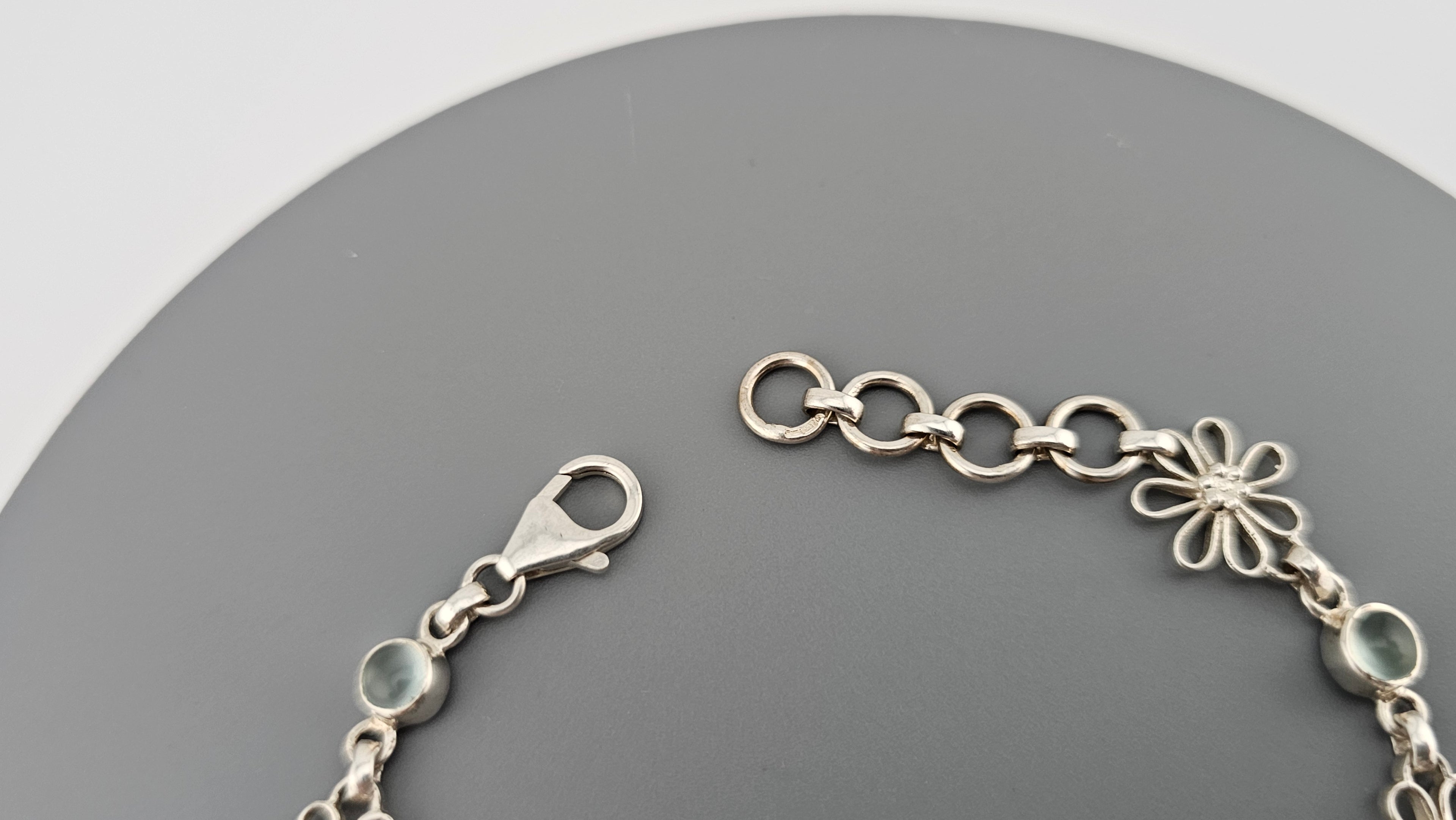925 sterling silver daisy link bracelet featuring light blue, round cabochon aquamarine