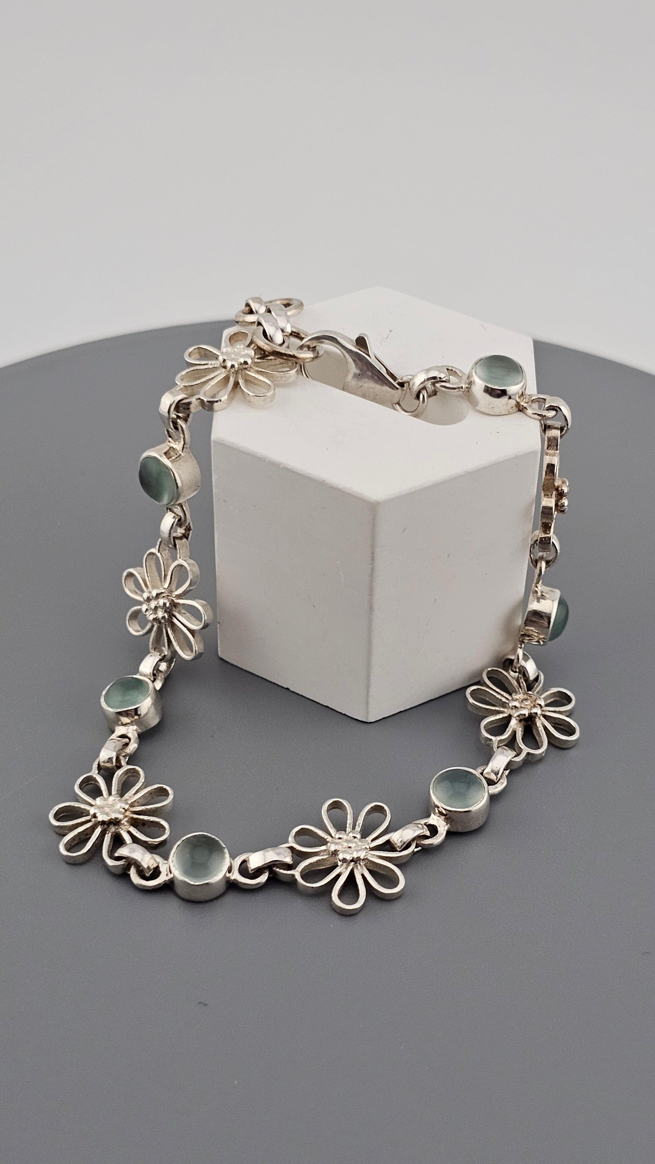 925 sterling silver daisy link bracelet featuring light blue, round cabochon aquamarine